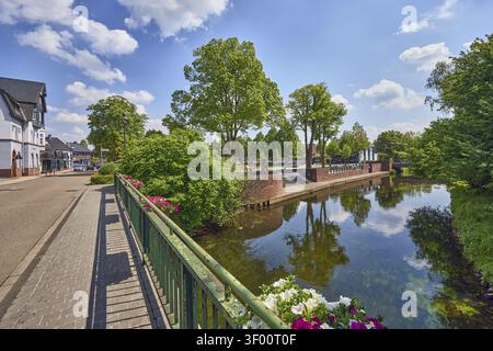 Fiume Niers, ponte per automobili e passerella pedonale, ringhiera in metallo, muro di mattoni, banchina, edifici generici, case, strade, fioriere, alberi, riflessi sul wa Foto Stock
