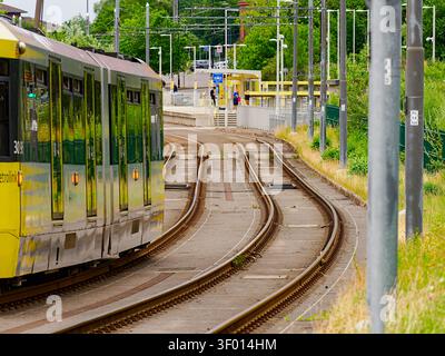 Salford, Manchester, Regno Unito, 4 luglio 2026: Tram Manchester Metrolink che entra in una stazione con binari curvilinei e banchina, che rappresenta il tragitto urbano A. Foto Stock