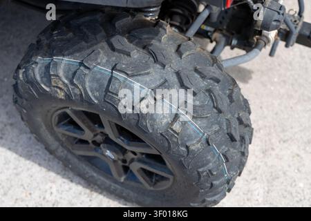 Vista dettagliata di uno pneumatico ATV knobby, che mostra il suo profilo aggressivo del battistrada progettato per la massima trazione su superfici impegnative Foto Stock