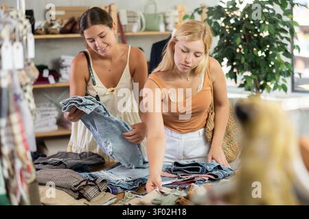 Due donne scelgono jeans di alta qualità nel negozio Foto Stock