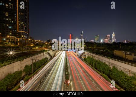 Soletti semaforici al tunnel del fiume Saigon con lo skyline di Ho Chi Minh City al crepuscolo del 13 febbraio 2026. Foto Stock