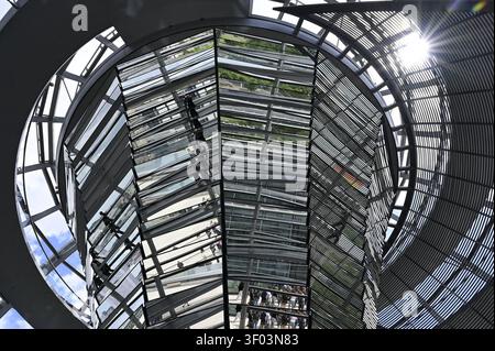 Der Plenarsaal. Die Lichtspindel, oft auch als Lichtkegel oder Spiegeltrichter bezeichnet, ist das architektonische und energetische Herzstück im Inneren der Glaskuppel des Reichstagsgebäudes, dem Sitz des Deutschen Bundestages a Berlino. Er erstreckt sich über zwei Etagen und wird von der weithin sichtbaren, 23 Meter hohen Glaskuppel gekrönt, durch die Tageslicht in den Saal geleitet wird. DAS Reichstagsgebäude a Berlino ist der offizielle Sitz des Deutschen Bundestages. Die Außenansicht ist geprägt von der historischen Neorenaissance-Fassade des Architekten Paul Wallot und der modernen, Weit Foto Stock