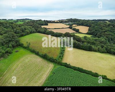 Veduta aerea del paesaggio agricolo ondulato di Restormel con campi di macchia, fitti siepi e macchie di bosco sotto un cielo nuvoloso Foto Stock