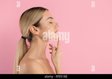 Giovane donna bella di profilo che tocca il mento con gli occhi chiusi Foto Stock
