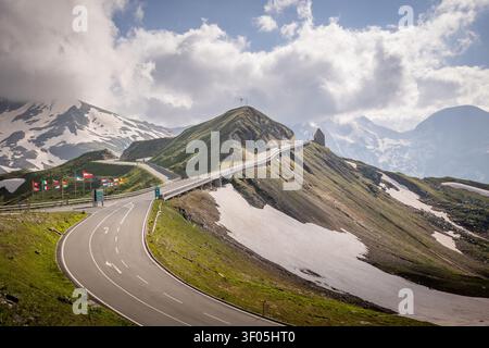 Passo montano della Großglockner-Hochwurzelstraße con bandiere europee e vette innevate Foto Stock