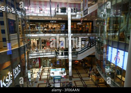 Ampia veduta dell'atrio centrale del centro commerciale Palladium a Praga con più livelli di negozi, scale mobili e marchi di vendita al dettaglio internazionali Foto Stock