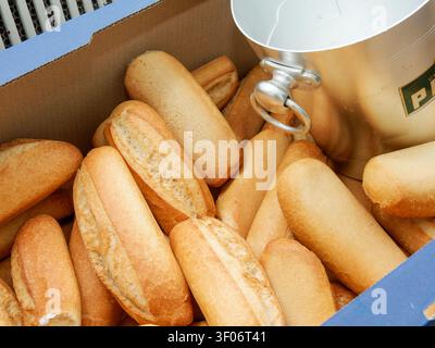 Panini freschi conservati in una scatola di cartone accanto a un secchio di ghiaccio in metallo durante un evento catering Foto Stock