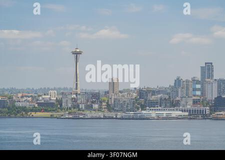 Vista panoramica diurna dello skyline e del lungomare del centro di Seattle, mostrando grattacieli, il paesaggio della baia e il paesaggio urbano sotto un cielo blu. Foto Stock