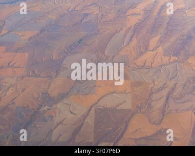 Vista aerea ad alta quota dei campi agricoli patchwork e delle colline aride e ondulate nell'arido paesaggio dello stato di Washington. Foto Stock