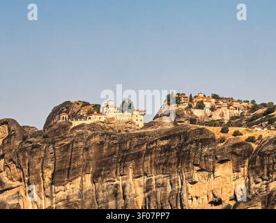 Kalambaka, Grecia - 24 luglio 2024: gruppo di monasteri Meteora: a sinistra c'è Varlaam con il suo piccolo padiglione aperto per le campane, e a destra c'è il Grande Meteoron, grande Foto Stock