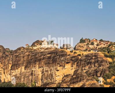 Kalambaka, Grecia - 24 luglio 2024: gruppo di monasteri Meteora: a sinistra c'è Varlaam con il suo piccolo padiglione aperto per le campane, e a destra c'è il Grande Meteoron, grande Foto Stock