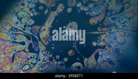 Liquido arcobaleno. Fuoriuscita di bolle. Superficie multicolore per acqua di benzina chimica. Fantasy sfocato spettro psichedelico mix inchiostro sfondo astratto. Foto Stock