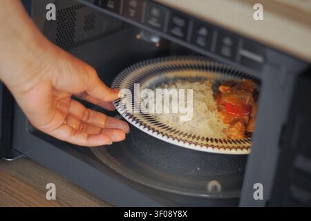 Cena deliziosa che si riscalda nel microonde a casa Foto Stock