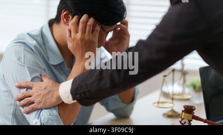 Cliente asiatico stressato che riceve conforto da un avvocato durante una consulenza legale Foto Stock