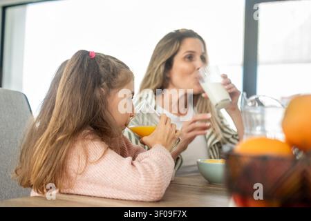 Madre e figlia che godono di una colazione sana insieme a casa Foto Stock
