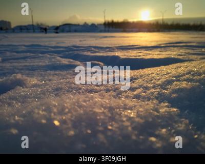 Prima piano di neve invernale scintillante all'ora dorata del tramonto Foto Stock