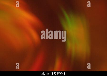 Immagine astratta con motivi di luce colorati, forme a vortice e sfumature nei toni del rosso, verde e arancione, che creano un effetto visivo dinamico Foto Stock