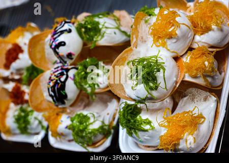 Close up di crepe thailandesi croccanti con panna montata, foi thong, guarnizione di pandan, salsa al cioccolato e ripieni di dessert colorati. Foto Stock