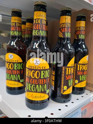 DENIA, SPAGNA - 11 ottobre 2025. Una varietà di bottiglie di birra biologiche, senza glutine e vegane è esposta su uno scaffale di un negozio in Spagna, attirando i clienti Foto Stock