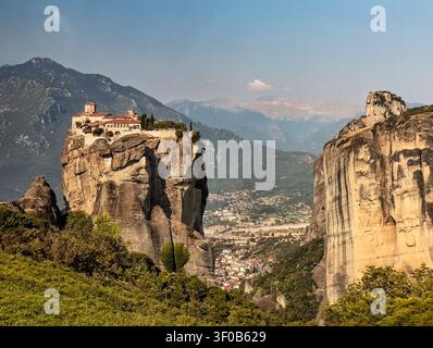 Kalambaka, Grecia – 24 luglio 2024: gruppo di monasteri di Meteora. Monastero di San Stefano sul proprio plateau roccioso e il paesaggio urbano di Kalambaka molto più in basso Foto Stock