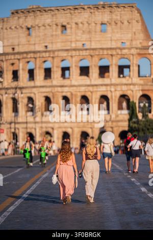 Due donne che camminano verso il Colosseo a Roma, Italia Foto Stock
