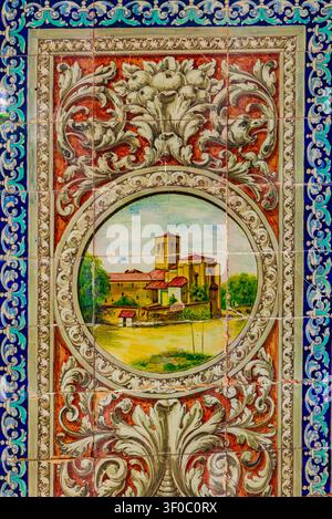 Tradizionale pannello in ceramica dipinto a mano raffigurante un edificio storico, incorniciato da motivi floreali ornati in Plaza de España a Siviglia, Spagna. Ricco A Foto Stock