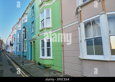 Case a schiera colorate su una strada residenziale soleggiata in una città costiera. Foto Stock