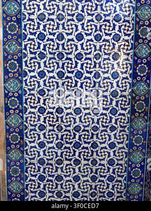 Istanbul - 24 set. 2024 - pannello di piastrelle ottomane dettagliato che mostra un complesso disegno geometrico a mosaico blu-bianco, evidenziando la tradizionale artigianalità Foto Stock