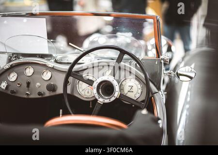 Prima vista del complesso cruscotto e del volante di un'automobile classica, che mostra il suo fascino vintage e la sua strumentazione dettagliata Foto Stock