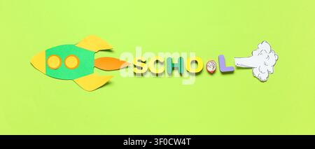 Razzo di carta con la parola della scuola su sfondo verde Foto Stock