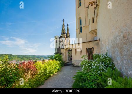 Antico giardino del castello gotico con torri che si affacciano su una vista panoramica della valle Foto Stock
