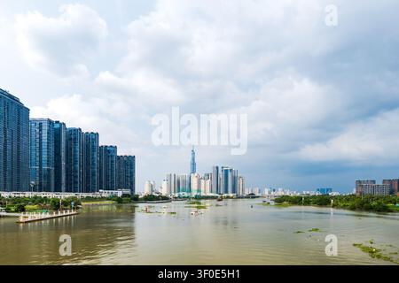 Panorama della città di Ho Chi Minh con la torre Landmark 81 riflessa nel fiume Saigon sotto un cielo nuvoloso drammatico, Vietnam Foto Stock