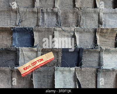Prima vista del retro di un tessuto patchwork di denim fatto a mano, tessuto da pezzi di jeans riciclati, con un'etichetta in 100% cotone Foto Stock