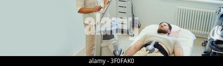 Testa di un giovane caucasico sdraiato su un letto medico durante una scansione diagnostica, tecnico che opera attrezzature di imaging in clinica. Utile per la tecnologia sanitaria, l'assistenza al paziente, il marketing della diagnostica Foto Stock