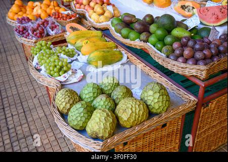 Un vivace mercato della frutta sull'isola di Madeira con una colorata esposizione di frutti tropicali e locali freschi, tra cui frutti della passione, papaye, avocado. Foto Stock