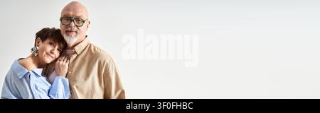 Una coppia di anziani amorevoli si tiene insieme, irradiando felicità nel loro abbigliamento alla moda. Foto Stock