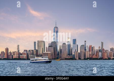 One World Trade Center e lo skyline di New York City visti al tramonto attraverso il fiume Hudson, con i grattacieli di Manhattan a Lower Manhattan, New York Foto Stock