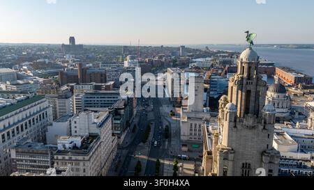 Un drammatico colpo aereo con drone che cattura l'iconica torre dell'orologio e il Liver Bird del Royal Liver Building a Liverpool l'8 luglio 2026. La telecamera Foto Stock