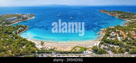 Vista aerea panoramica estiva della famosa spiaggia di lusso Astir nel sud di Atene, baia di Vouliagmeni, Grecia, con sport acquatici su un mare turchese Foto Stock