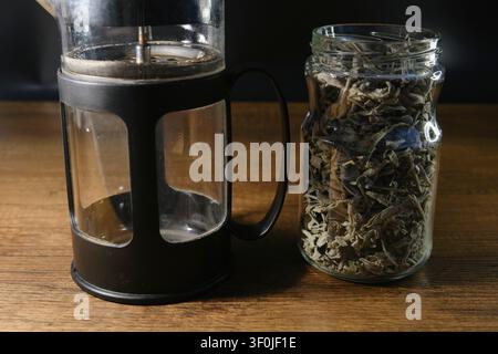 Prima vista di tè alle erbe e salvia in infusione all'interno di una french press in vetro Foto Stock