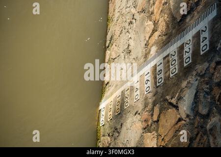 Misuratore del livello dell'acqua del fiume montato sul muro del canale Foto Stock