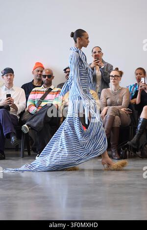 Berlino, Germania, 5 luglio 2026. Una modella sfila per Fruche in un vestito a strati blu a righe durante la sfilata della Berlin Fashion Week SS27. Foto Stock