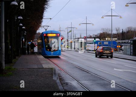 Stoccolma, Svezia-28 novembre 2025: Tram blu che percorre la strada Strandvägen a Stoccolma accanto a un'auto. Foto Stock