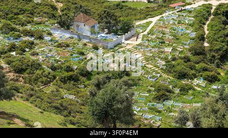 Una vista aerea del cimitero musulmano di Sidi Ahmed el Ouafi mostra file di segnagioli bianchi sparsi sulla collina verde sopra la medina, su Foto Stock