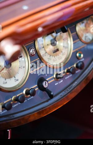 Cruscotto in legno di un'auto sportiva classica MG con tachimetro, interruttore di accensione, soffietto e comandi dell'acceleratore e badge ottagonale MG, Museo di Brooklands, W Foto Stock