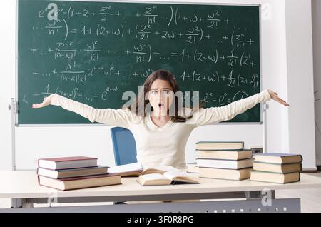 Femmina giovane insegnante di matematica di fronte a lavagna Foto Stock