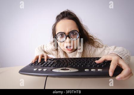 Funny nerd ragazza che lavora sul computer Foto Stock
