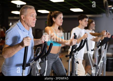 Corsa a piedi su allenatori ellittici in palestra moderna Foto Stock