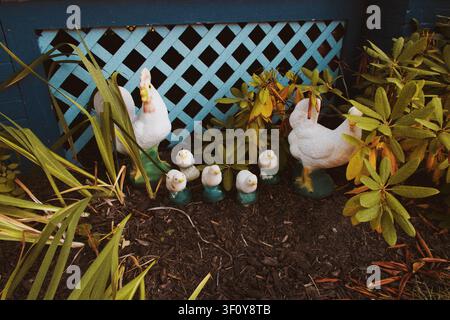 Strane figurine di gallina in un giardino anteriore Foto Stock
