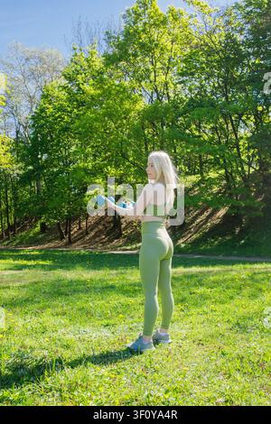 Bella donna bionda sportiva che fa esercizi con i manubri Foto Stock
